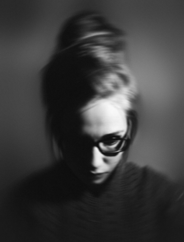women in greyscale wearing glasses, blurred out