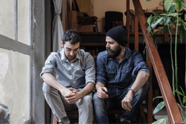 Two men sitting on the stairs.