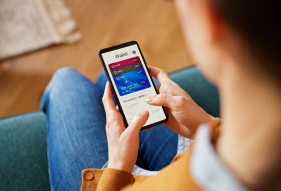 A woman looking down at her phone showing her latest bank transactions.