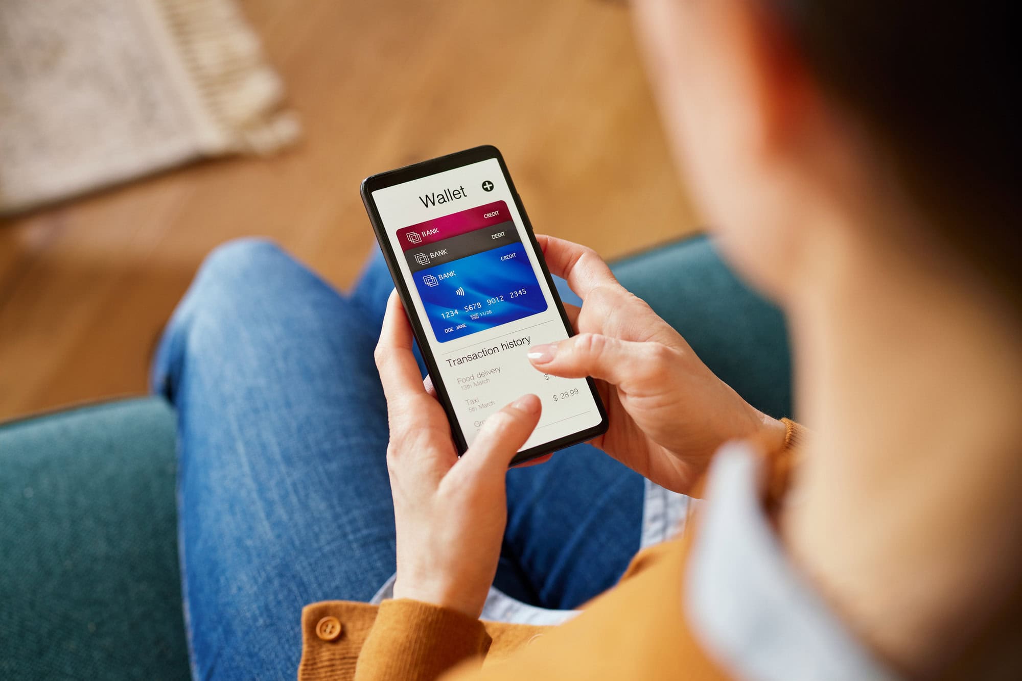 A woman looking down at her phone showing her latest bank transactions.